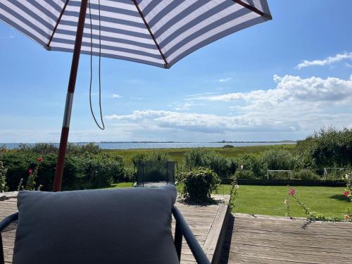 a chair sitting on a deck under an umbrella at BBL59 in Fåborg