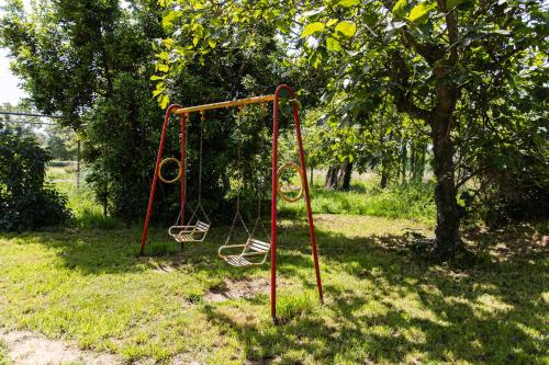 an empty swing set in a park with a tree at Agroturisme Sant Dionis in Campllong