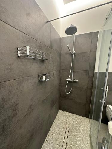 a shower with a glass door in a bathroom at Modern flat with a stunning view in Cuneo center in Cuneo
