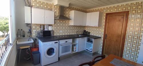 a kitchen with a washing machine and a washer at Appartement Spacieux fonctionnel Parking assuré!! in Novelda