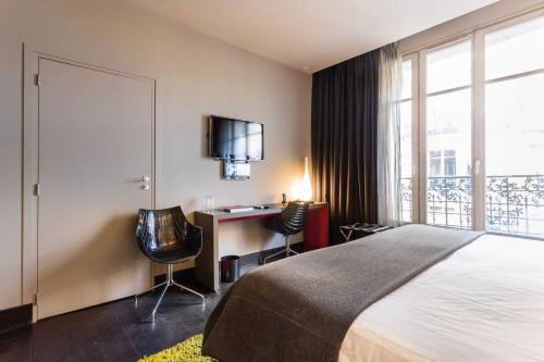 une chambre avec un lit, un bureau et une fenêtre dans l'établissement Residence Fremiet Tour Eiffel, à Paris