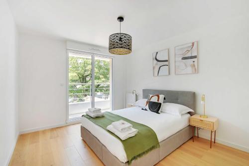 une chambre blanche avec un lit et une fenêtre dans l'établissement Exclusive Duplex -5BD-10P- Nogent-sur-Marne, à Nogent-sur-Marne