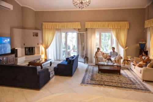 a group of people sitting in a living room at Villa Agapi Sani in Sani Beach