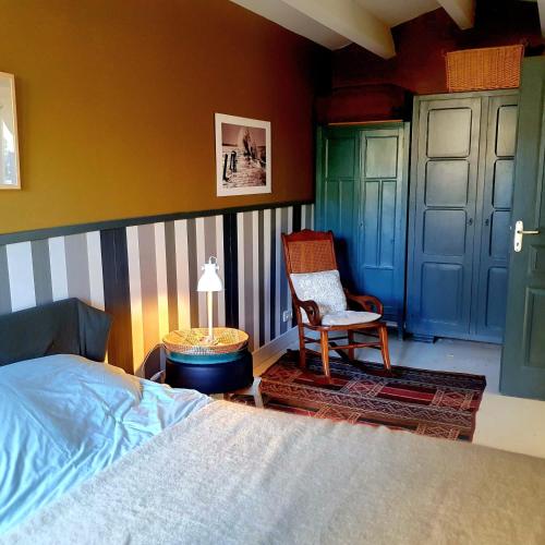 une chambre avec un lit, une chaise et une table dans l'établissement Villa Margot, à Saint-Pierre-dʼOléron