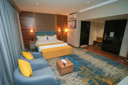 a hotel room with a bed and two couches at Almsakn Alola Hotel Company in Riyadh