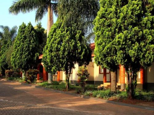 a row of trees in front of a house at Bethel Court Vineyard Hotel in Ezulwini