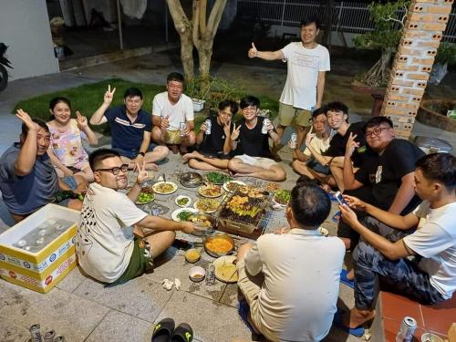 a group of people sitting around a table eating food at Khách sạn AN THỊNH 2 in Doc Let