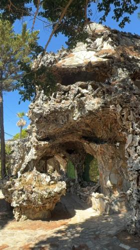 an old stone building with trees in the background at Rooms the other side of the island by Patitiri in Saterlí