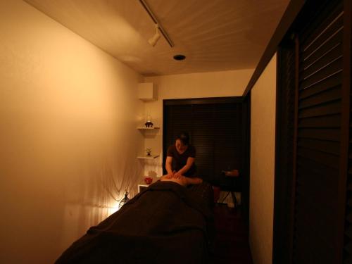 a woman sitting on a bed in a room at Sekitaitei Ishida in Achi