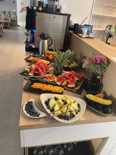 a table with three plates of fruit and vegetables on it at Hotel Manor in Mamaia Nord