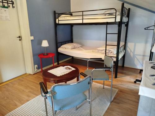 a room with two bunk beds and a table and chairs at Charlottsborgs Camping och Vandrarhem in Kristianstad