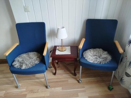 two blue chairs with furry pillows sitting next to a table at Charlottsborgs Camping och Vandrarhem in Kristianstad