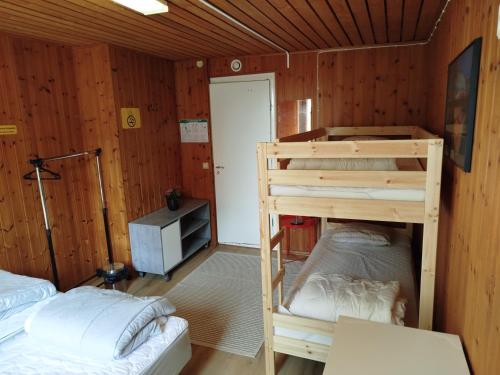two bunk beds in a room with wooden walls at Charlottsborgs Camping och Vandrarhem in Kristianstad
