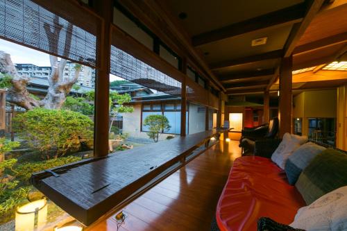 a living room with a couch and a large window at Sekitaitei Ishida in Achi