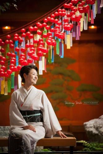 a woman is sitting on a bench with a bunch of paper tags at Sekitaitei Ishida in Achi