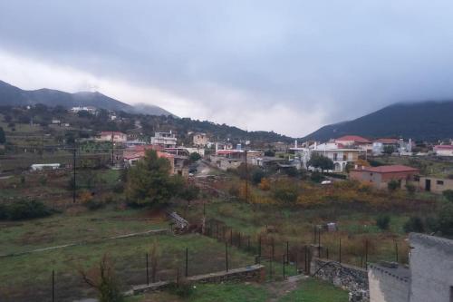 a small town in a field with a mountain at Christos House in Zárakes