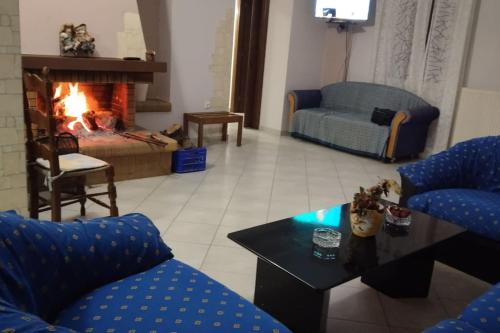 a living room with a couch and a fireplace at Christos House in Zárakes