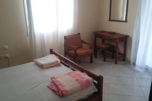 a bedroom with a bed and a chair and a table at Christos House in Zárakes