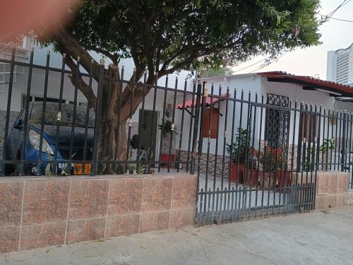 une clôture noire avec un arbre devant un bâtiment dans l'établissement Apartamento Cartagena Torices 50, à Carthagène des Indes