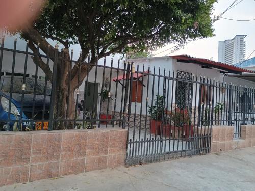 une clôture avec un arbre devant un bâtiment dans l'établissement Apartamento Cartagena Torices 50, à Carthagène des Indes