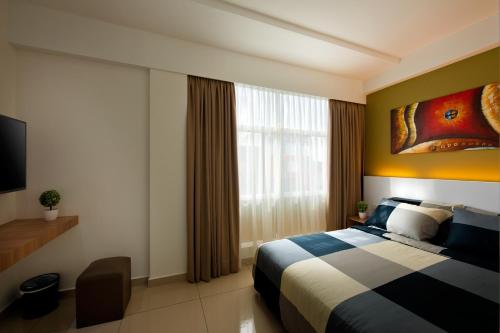 a hotel room with a bed and a window at Rivero Boutique Hotel Melaka in Melaka