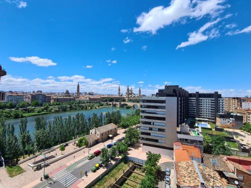 vista su una città con un fiume e su edifici di Dos Torres Ribera Play & Relax con Jacuzzi y cine a Saragozza