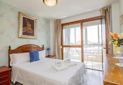 a bedroom with a bed and a large window at Cubo's Beach Side Diana Apartment in Benalmadena Costa