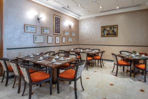 a restaurant with tables and chairs in a room at Bristol Hotel in Amman