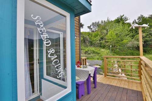 a door to a patio with a table on a deck at Gyeongju Novios Pets Friendly Pension in Gyeongju