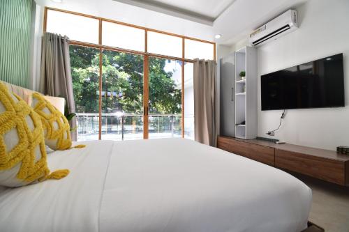 a bedroom with a large bed and a large window at Don Arc White Beach Resort in Initao