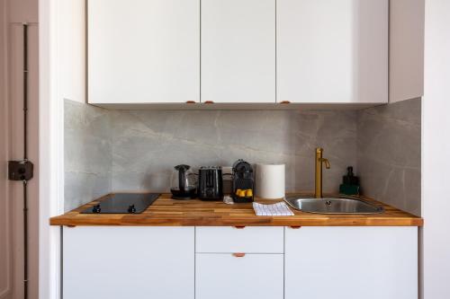 une cuisine avec des armoires blanches et un évier dans l'établissement The charming Republic Place, à Paris