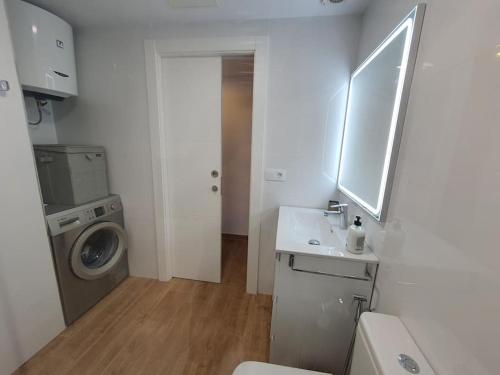 a bathroom with a sink and a washing machine at Vivienda Vacacional frente al mar Playa del Aguila in Playa del Aguila