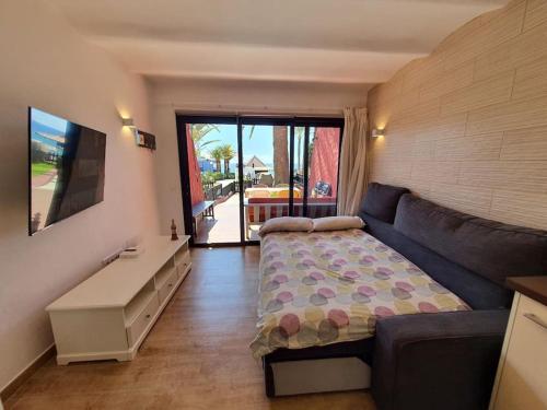 a bedroom with a bed and a couch and a table at Vivienda Vacacional frente al mar Playa del Aguila in Playa del Aguila