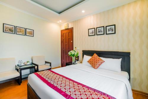 a bedroom with a bed and a table and a chair at Ha Noi Lake View Hotel & Travel in Hanoi