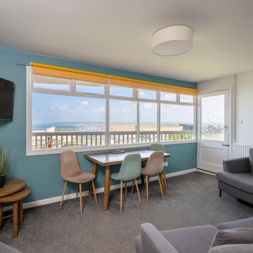 a living room with a table and chairs and a large window at Braddicks Holiday Centre in Westward Ho