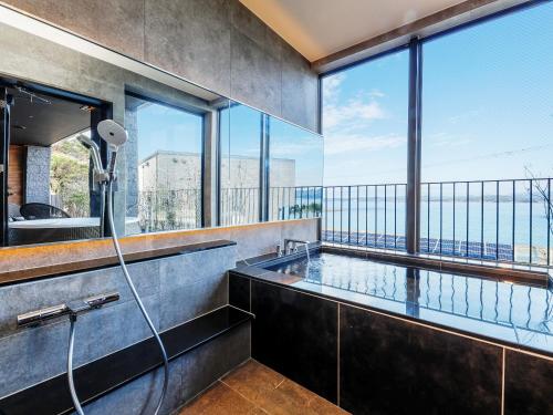 a bathroom with a shower with a large window at FIVE SPRING RESORT THE SHIRAHAMA in Shirahama