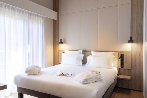a bedroom with a large white bed with towels on it at Novotel Megève Mont-Blanc in Megève