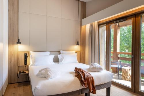 a bedroom with a bed with towels on it at Novotel Megève Mont-Blanc in Megève