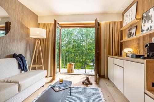 a living room with a couch and a table at Novotel Megève Mont-Blanc in Megève