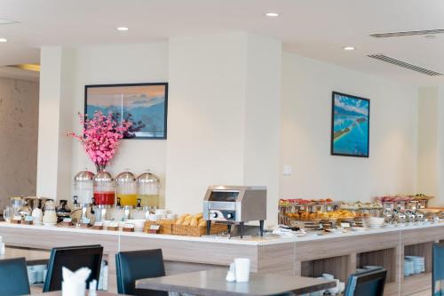 un restaurant avec un comptoir avec de la nourriture dessus dans l'établissement ARECA HOTEL NHA TRANG, à Nha Trang
