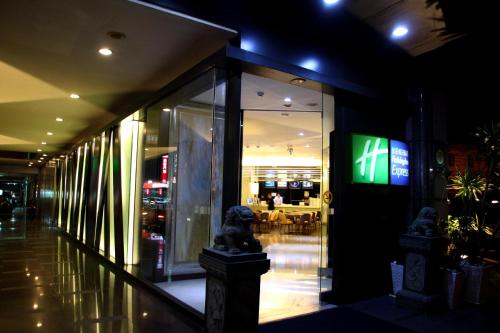 a store front at night with a sign in the window at Holiday Inn Express Taoyuan by IHG in Taoyuan