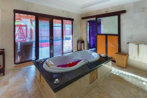 a large bathroom with a bath tub in a room at Private Pool Villas in Kuta