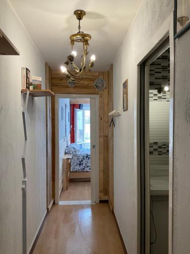 a hallway leading to a bedroom with a chandelier at Metz gare arènes centre ville studio 40m2 in Metz