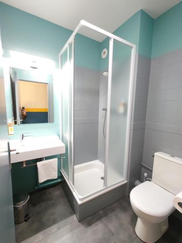 a bathroom with a shower and a toilet and a sink at greet hotel Grenoble Centre Gare in Grenoble