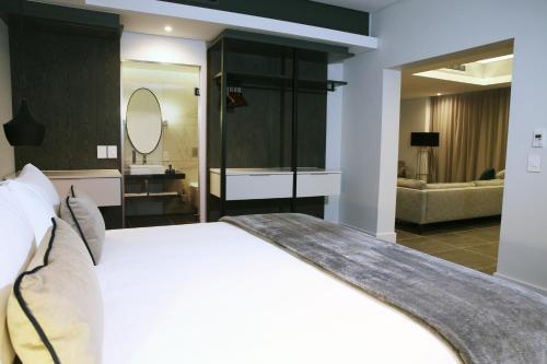a hotel room with a large bed and a large mirror at The Capital Mirage in Cape Town
