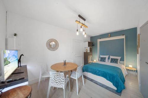 une chambre avec un lit et une table avec des chaises dans l'établissement Le Cocon Bleu Confort et Calme au centre ville Beaune, à Beaune
