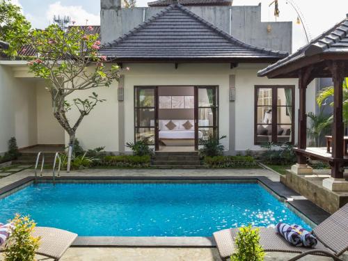 a swimming pool in front of a house at Dura Villas Bali at Kerobokan in Kerobokan