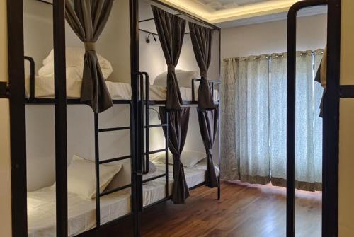 two bunk beds in a room with a window at The Clove Ladakh by LexStays in Leh