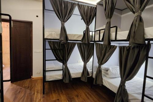 two bunk beds with drapes in a room at The Clove Ladakh by LexStays in Leh