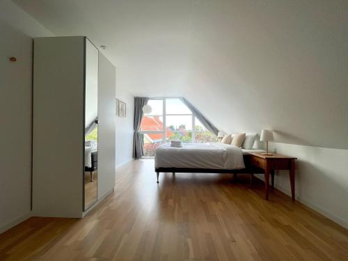 a bedroom with a bed and a table and a window at Kirsebærkroen - The Inn Between in Præstø